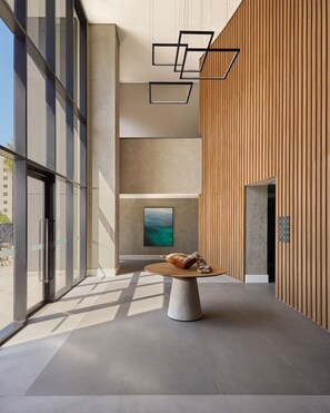 A modern interior with a round table, a painting, and a wooden wall. - Expand Pinheiros (São Paulo)