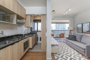 A modern apartment with a kitchen, a dining area, and a living room. - Expand Pinheiros (São Paulo)