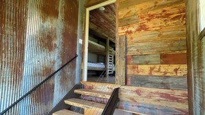 A wooden staircase with a metal railing leading to a room with a wooden ceiling and a chandelier. - Stunning Lodge Experience in Buffalo County WI/Picturesque Views-Pet Friendly! (Mondovi)