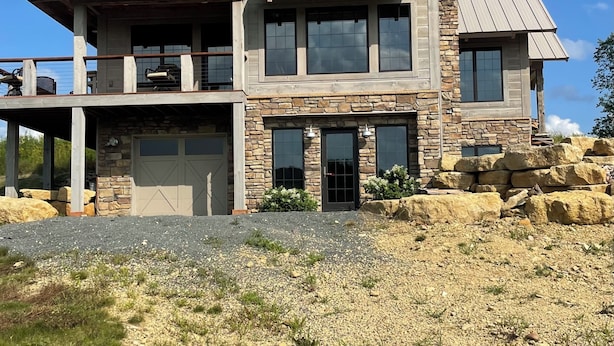A two-story house with a stone facade, large windows, and a metal roof. - Stunning Lodge Experience in Buffalo County WI/Picturesque Views-Pet Friendly! (Mondovi)