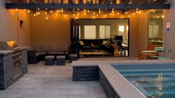 An outdoor patio area with a pool, stone seating, and string lights. - Serenity: Private Pool + Golf + Sand Dunes (Hurricane)