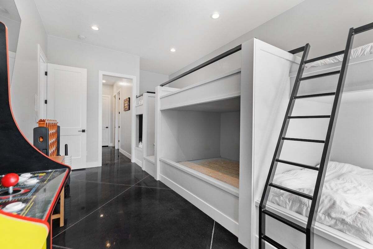 Une chambre avec des lits superposés, une échelle et une petite table sur laquelle on peut jouer à un jeu.