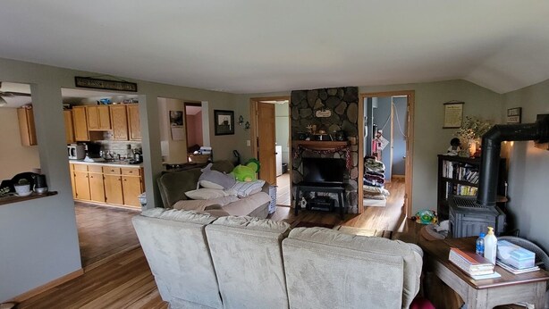 Una sala de estar acogedora con chimenea, un comedor y una cocina a la vista, separadas por un arco.