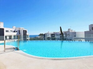 A rooftop swimming pool with clear blue water, surrounded by modern buildings and a clear sky. - Luxurious Flat With Jacuzzi and Pool at Higueron (Fuengirola)