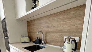 A modern kitchen with a built-in sink, a coffee maker, and a microwave. - Luxurious Flat With Jacuzzi and Pool at Higueron (Fuengirola)