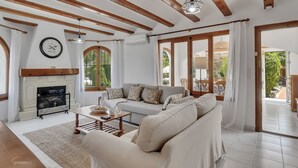 A spacious living room with a fireplace, a sofa set, and large windows. - Casa del Limonero (Javea / Xàbia)