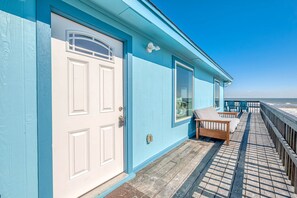 Enjoy the seaside view from the deck, featuring a window with a white frame and a comfortable bench.