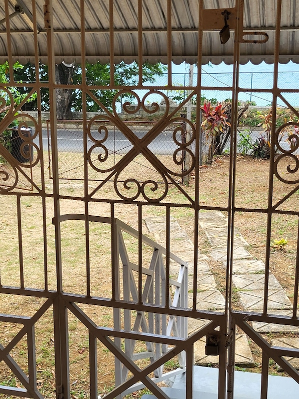 Secure entrance to a serene outdoor area with a beautifully designed gate and well-manicured surroundings.