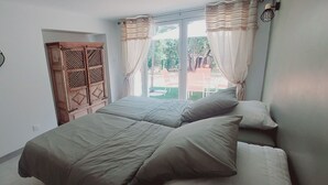 A bedroom with two beds, a wardrobe, and heart-shaped decorations on the wall. - Location à la Semaine (Néoules)