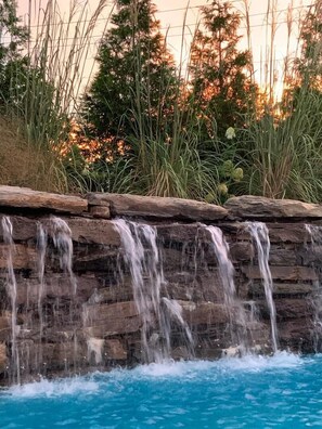 A waterfall cascading over a rocky ledge into a pool.