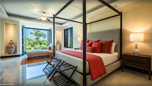 A four-poster bed with a red throw, a nightstand, and a lamp. - Punta Mita Resort (Punta de Mita)