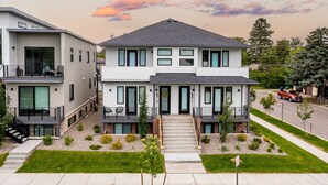 A modern two-story house with a front entrance, a balcony, and a driveway. - 5-minute walk to downtown!   27-day minimum rental.  (Bozeman)