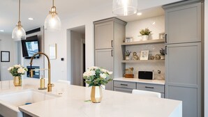 A modern kitchen with a large island, pendant lights, and built-in cabinets. - 5-minute walk to downtown!   27-day minimum rental.  (Bozeman)