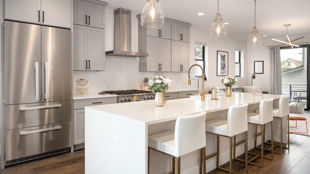 A modern kitchen with stainless steel appliances, white cabinetry, and a central island with bar stools. - 5-minute walk to downtown!   27-day minimum rental.  (Bozeman)