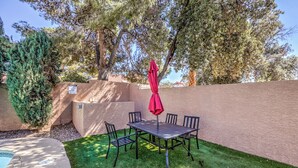 A patio with a table and chairs, surrounded by a low wall and a pool. - Heated Pool & Spa, Billiards, 15 Min Vegas Strip (Henderson)