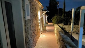 A stone building with a paved pathway leading to a door. - Vi Ja Villa Janas  (Sestu)