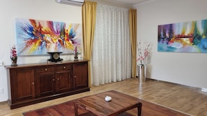A living room with a wooden cabinet, a coffee table, and two abstract paintings. - Vi Ja Villa Janas  (Sestu)