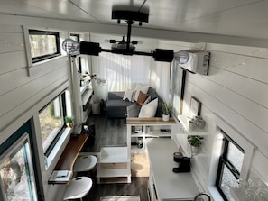 Un espacio habitable compacto con sofá, mesa de centro y zona de comedor.