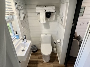 Ein kleines Badezimmer mit Toilette, Waschbecken und Handtuchhalter.