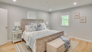 A bedroom with a bed, nightstands, a bench, and a window. - Middletown Vacation Rental: 2 Mi to Beach! (Middletown)