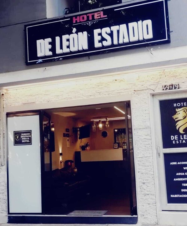 Entrada de un hotel con un letrero que dice 'Hotel De León Estadio'.