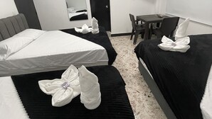Een hotelkamer met twee bedden, een bureau, een stoel, een flatscreen televisie en een deur.