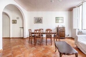 Un comedor con una mesa y sillas de madera, un banco y un armario.