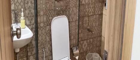 Un baño con inodoro, lavabo y ducha.