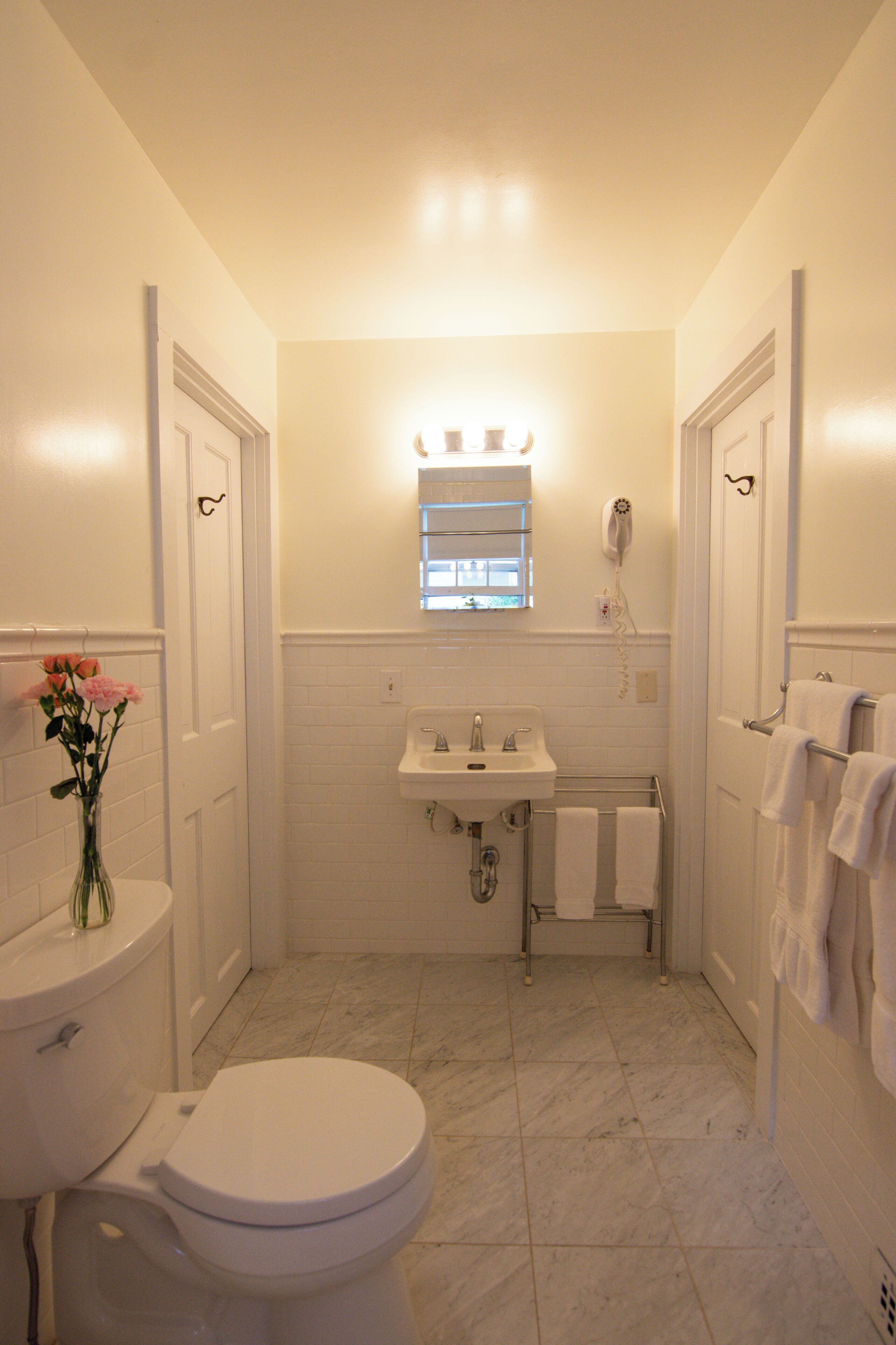 A bathroom with a toilet, sink, and a shower area.