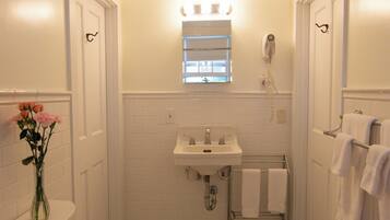 A bathroom with a toilet, sink, and a shower area.