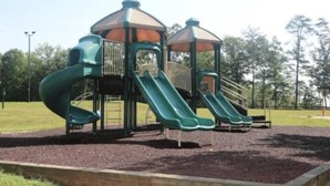 Un parque infantil con toboganes y una estructura de juegos cubierta.