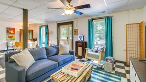 A living room with a blue sofa, a wooden coffee table, and a ceiling fan.