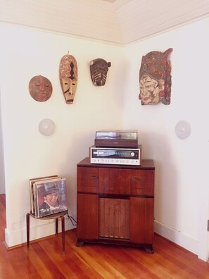 Relax in this cozy space with a stereo system, vinyl record player, and decorative masks on the wall.