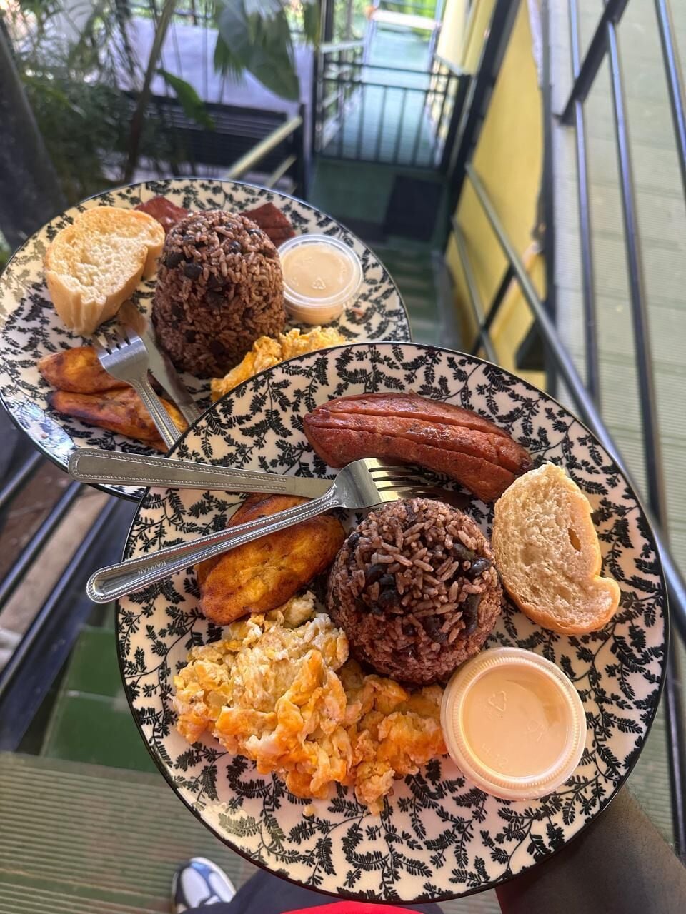 Un plat de menjar amb arròs, botifarra, torrades i ous barrejats sobre una taula amb dibuixos.