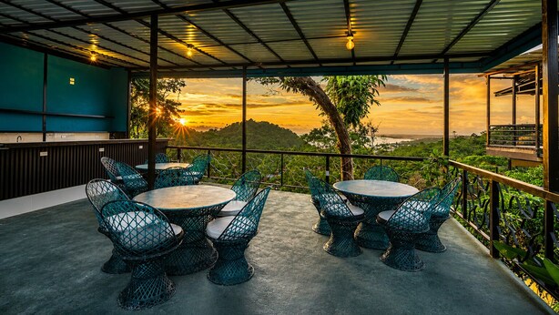 Un espace extérieur abrité, doté de tables et de chaises, offrant une vue sur un paysage pittoresque.
