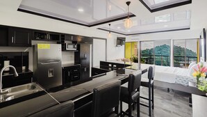 Une cuisine moderne dotée d’un grand îlot central, d’appareils électroménagers intégrés et d’un coin repas offrant une vue agréable.