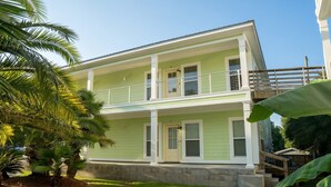 A two-story house with a balcony, a front porch, and a stone foundation. - Unwind After Work · 3BR 2BA · King Beds · W/D (Moss Point)