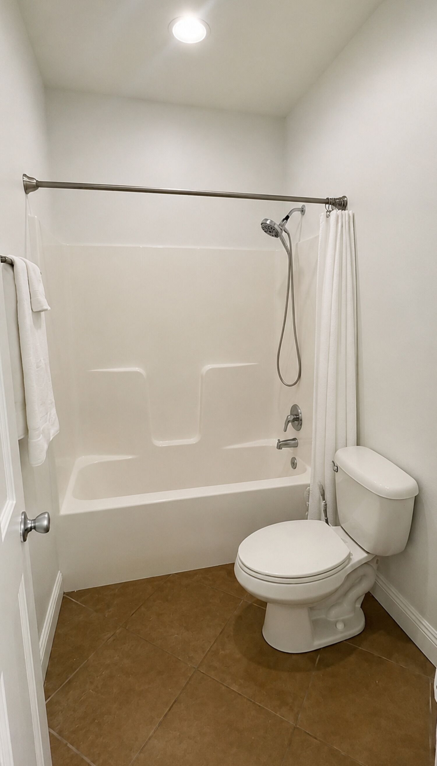 A bathroom with a bathtub, toilet, and shower curtain.
