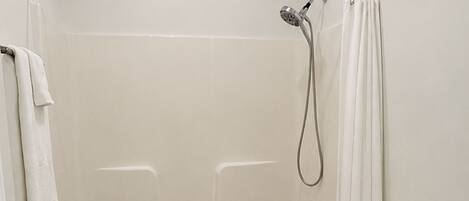 A bathroom with a bathtub, toilet, and shower curtain.