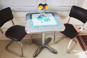 Enjoy a quiet moment with a vase of flowers on a table and two comfortable chairs.