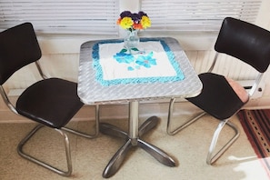 Enjoy a quiet moment with a vase of flowers on a table and two comfortable chairs.