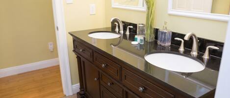 A bathroom with two sinks, dark wooden cabinets, and a mirror above the sink.