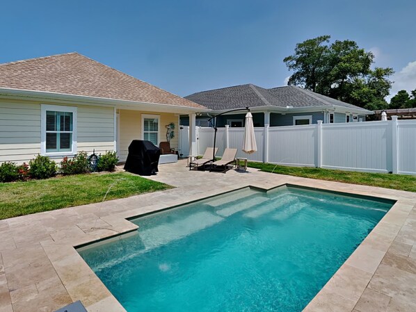 A backyard with a swimming pool, a barbecue grill, and a covered patio area. - Sun Kissed Memories by Southern Vacation Rentals (Panama City Beach)