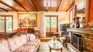 Un salón amplio con un sofá grande, una chimenea y un cuadro en la pared.