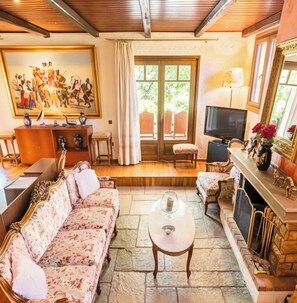 A living room with a sofa, a coffee table, a television, and a fireplace. - Luxury Country Estate with Pool, Olive Groves & Event Spaces (ΜΑΡΑΘΩΝΑΣ)
