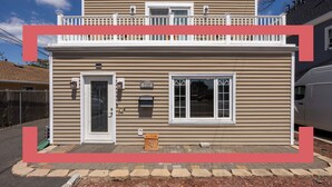 A two-story building with a front door, windows, and a mailbox.