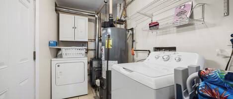 A laundry room with a washer, dryer, and stacked laundry baskets.