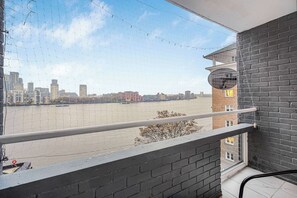 A balcony with a view of a river and cityscape. - Thames River View 3-Bedroom Apartment · Sleeps 8 · Free Secure Parking (London)