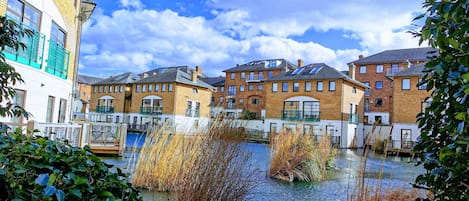 A riverside view with buildings, a bridge, and a clear sky.