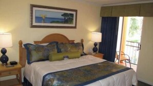 A hotel room with a bed, two bedside tables, a painting on the wall, and a view of the outdoors. - Orlando Christmas Week! (Orlando)